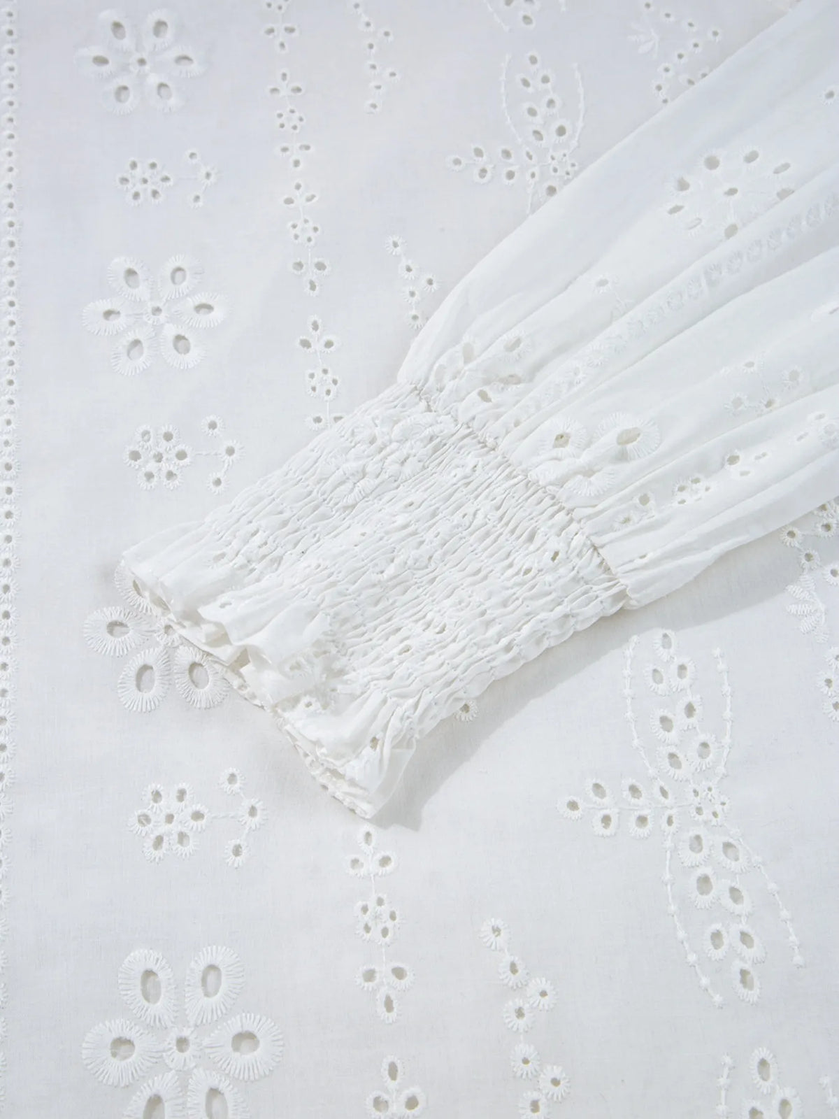 White eyelet blouse styled with trousers
