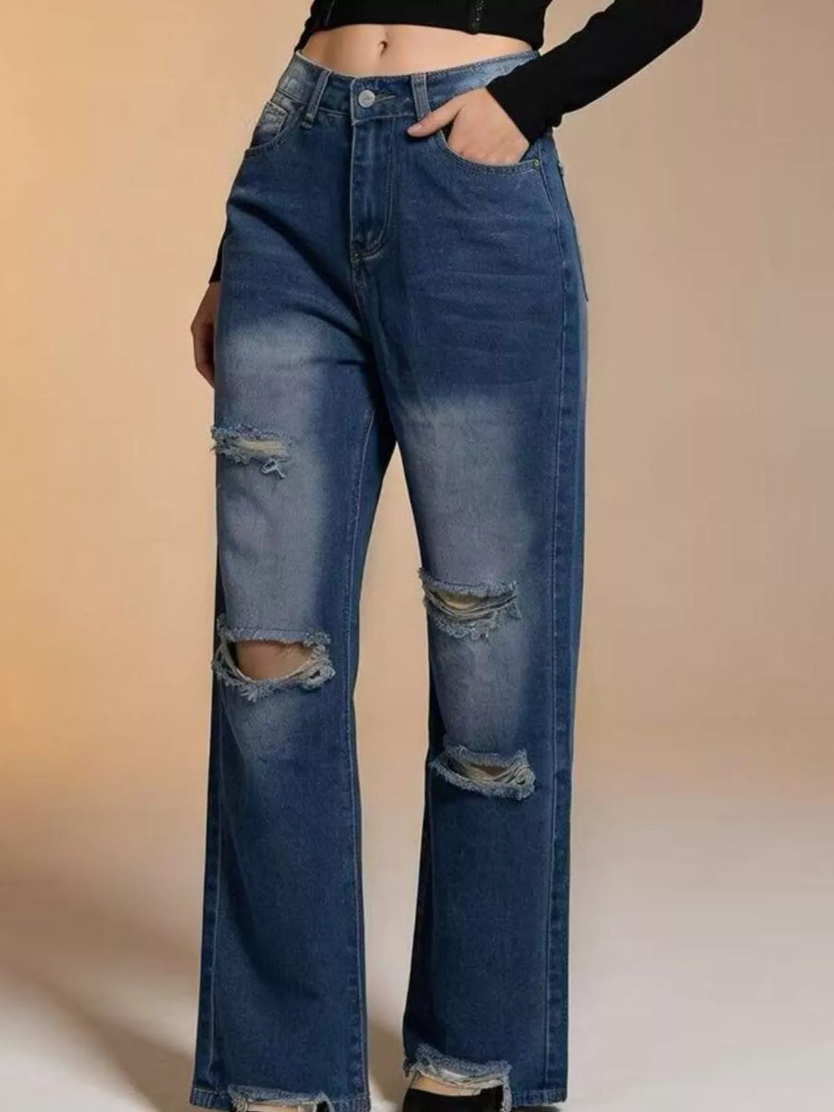 Model wearing distressed blue jeans