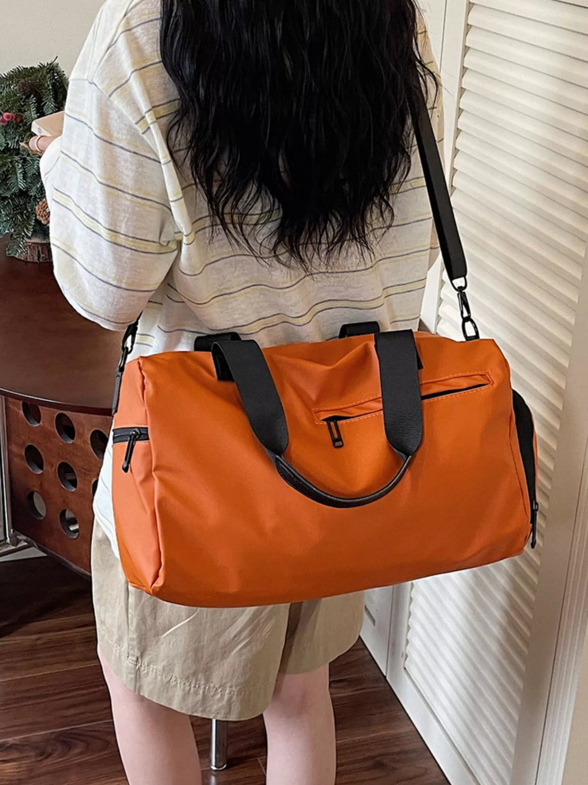 Orange duffel bag with multiple pockets side view
