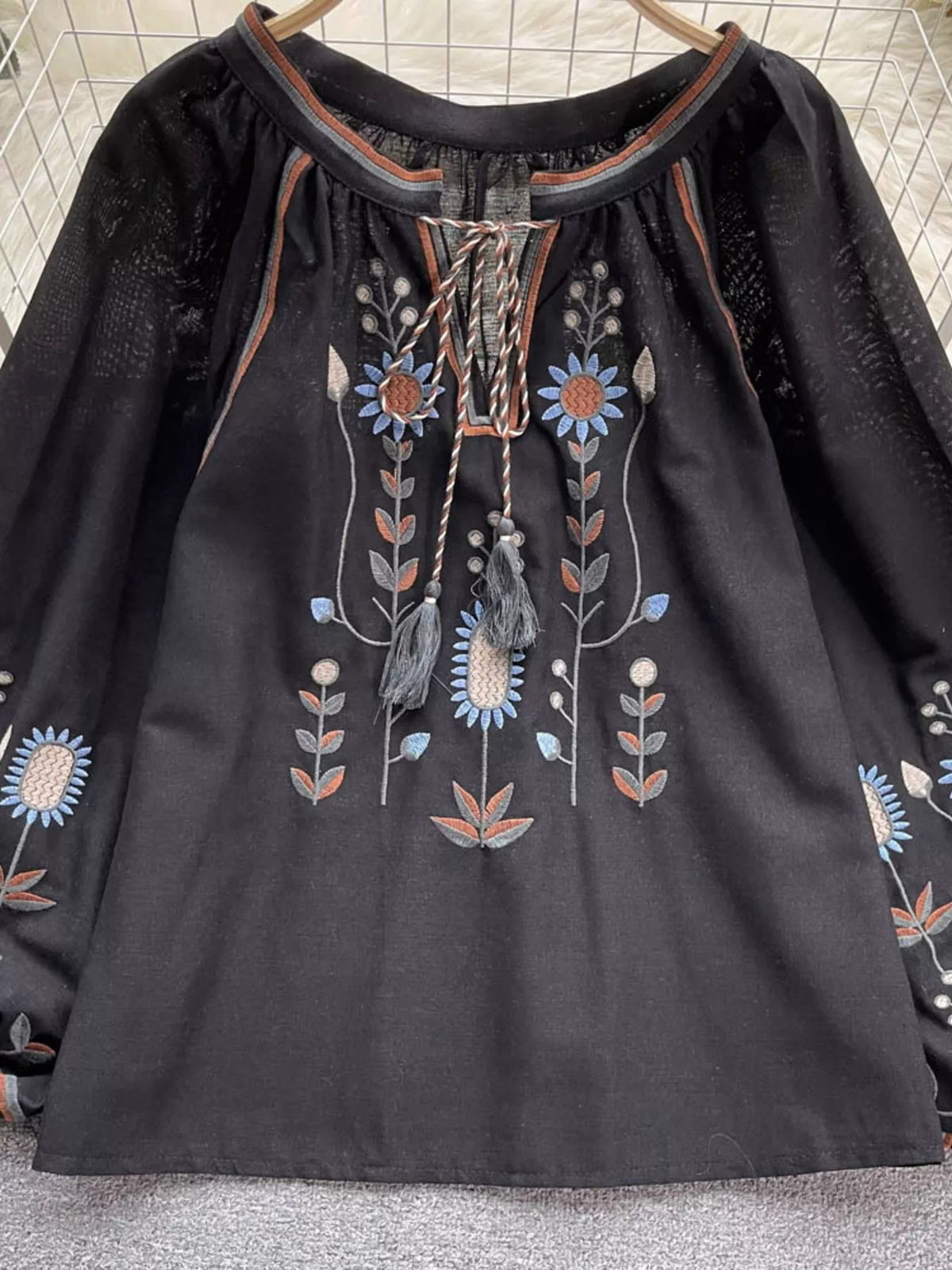 Embroidered tie neck blouse in black, front view