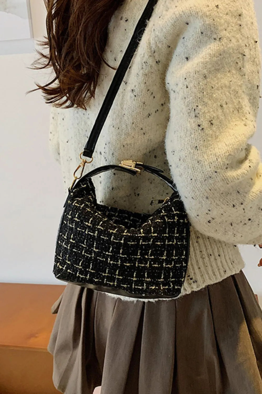 Woven shoulder bag carried by model