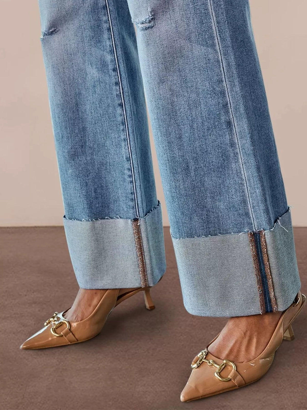 Distressed flare jeans showing raw hem