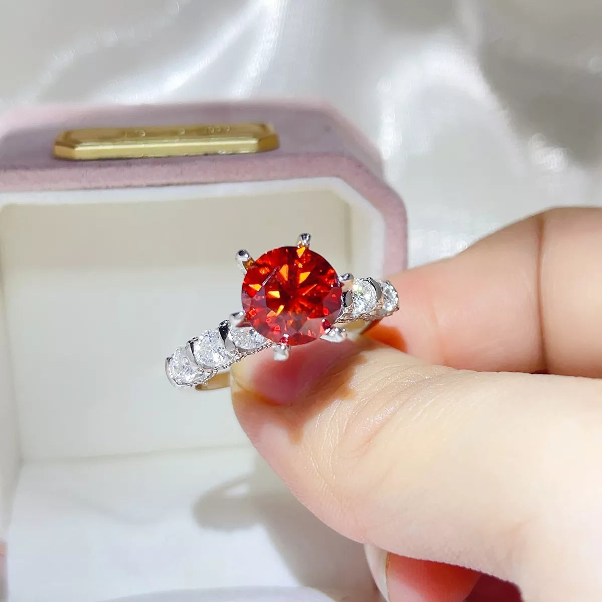 Red moissanite ring shown at an angle to display the silver setting