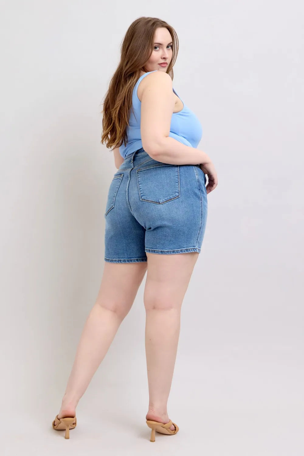 Three quarter view of the medium wash shorts