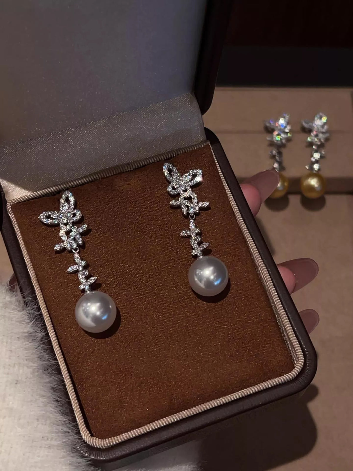 Butterfly pearl drop earrings in white front view