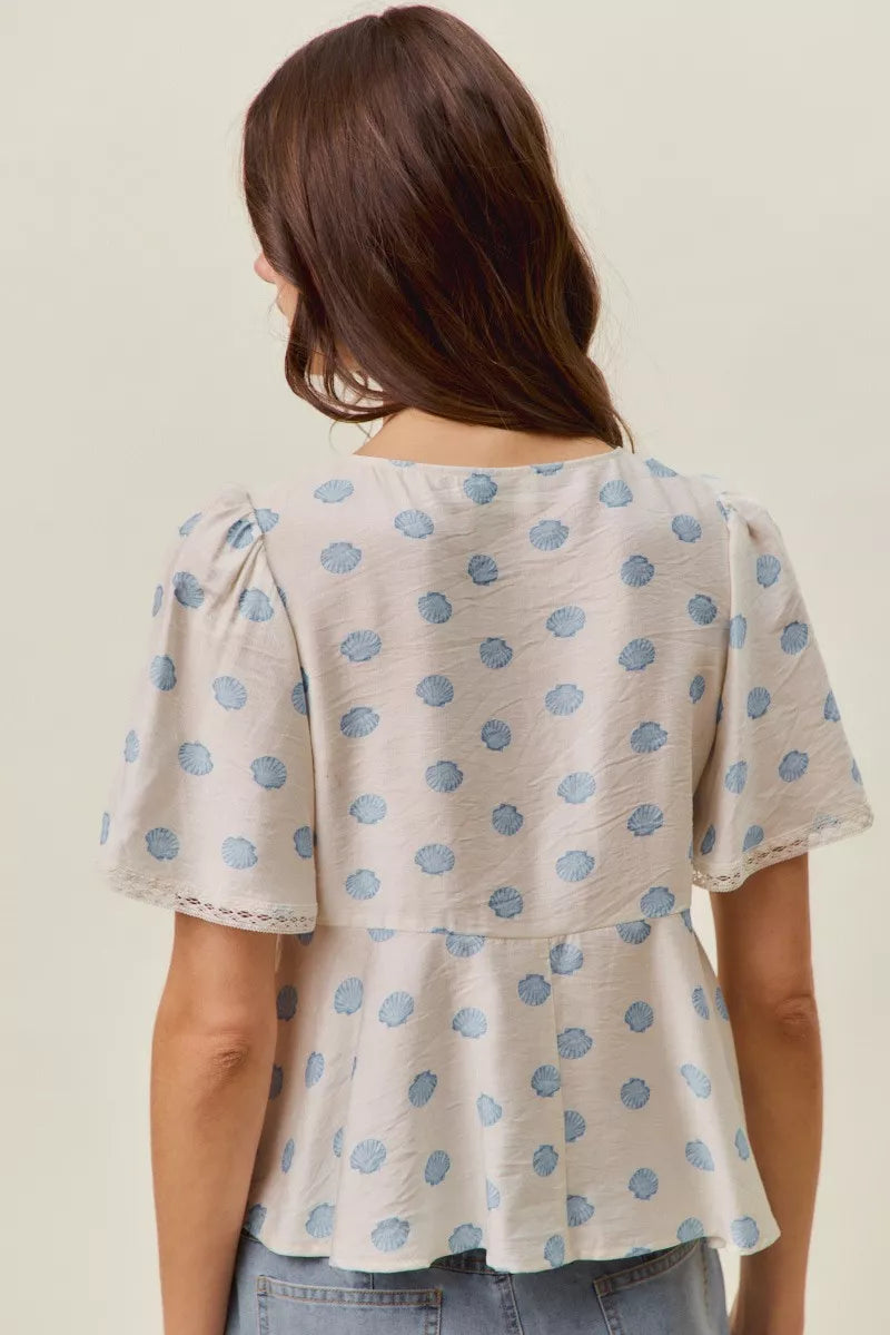 Ivory and blue shell print tie front flutter sleeve blouse side view