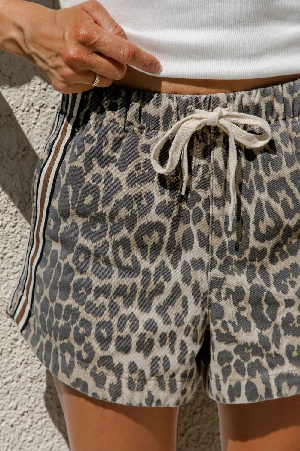 Printed denim shorts shown at a side angle with striped detail