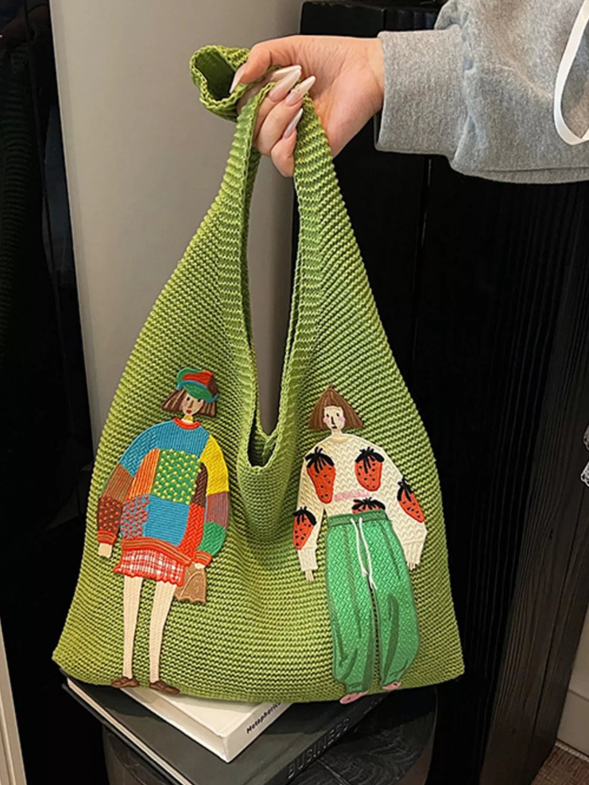 Model carrying green knitted shoulder bag