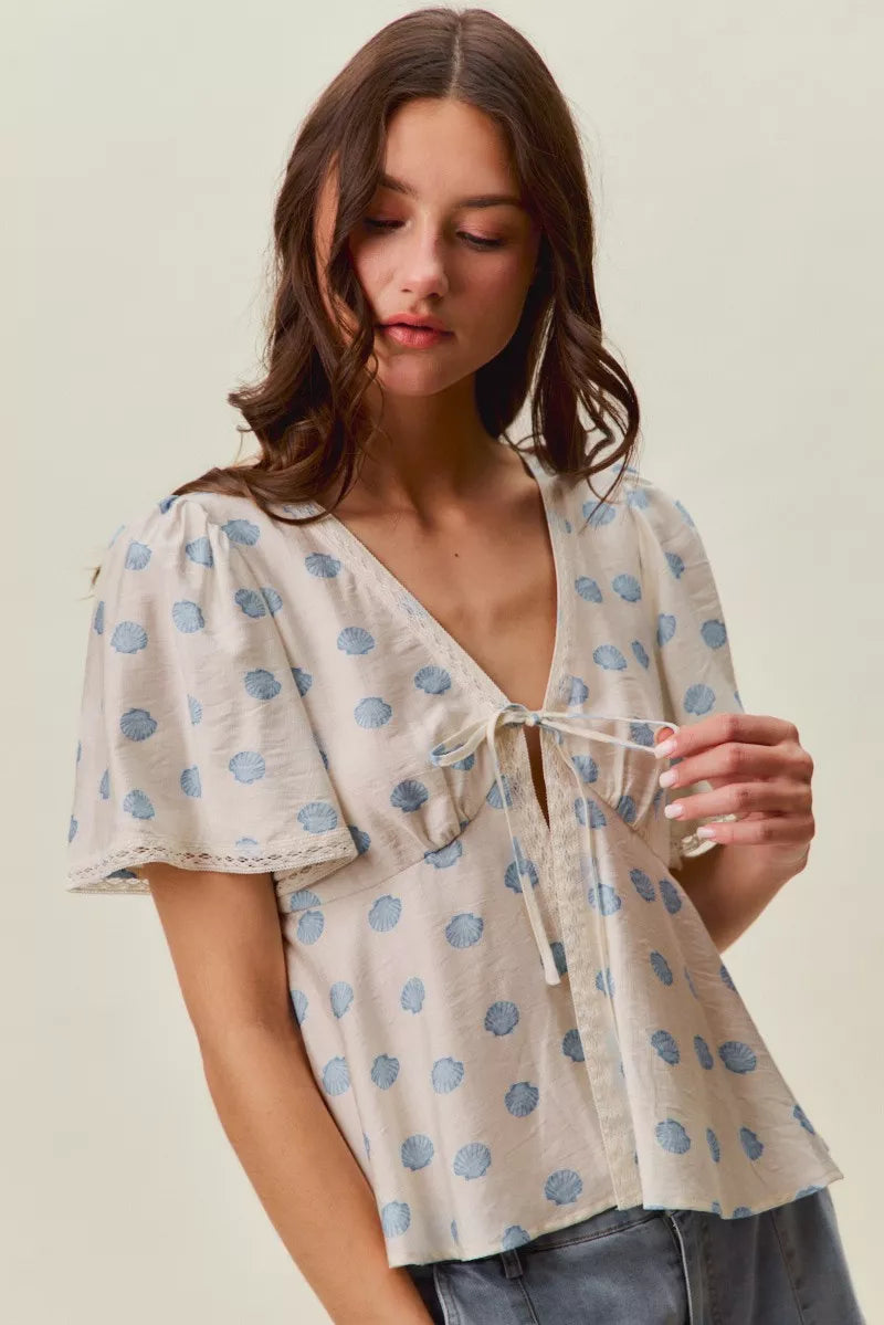 Ivory and blue shell print tie front flutter sleeve blouse front view