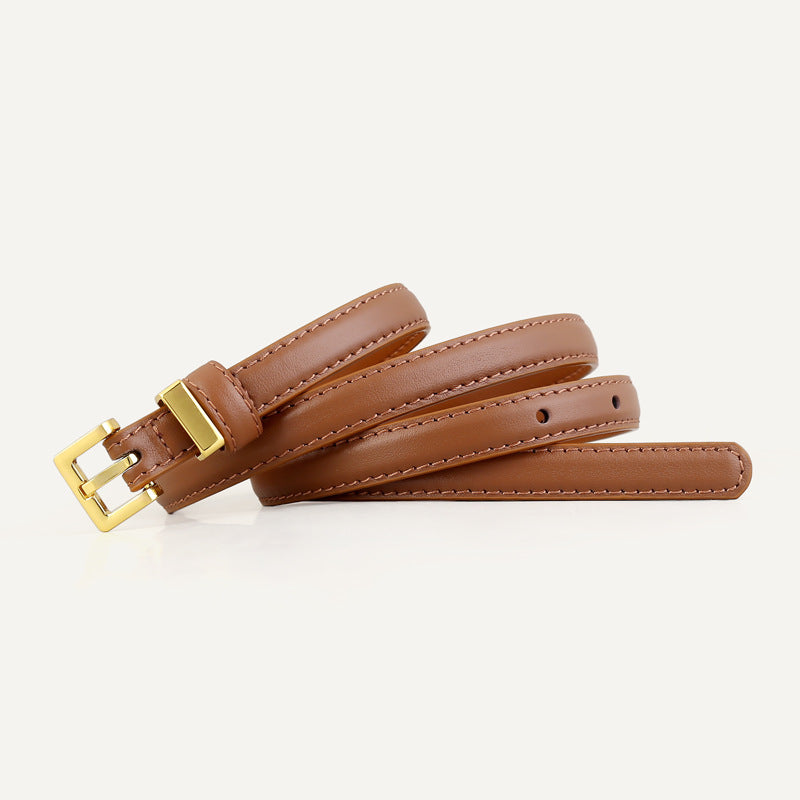 Skinny leather belt with golden buckle coiled