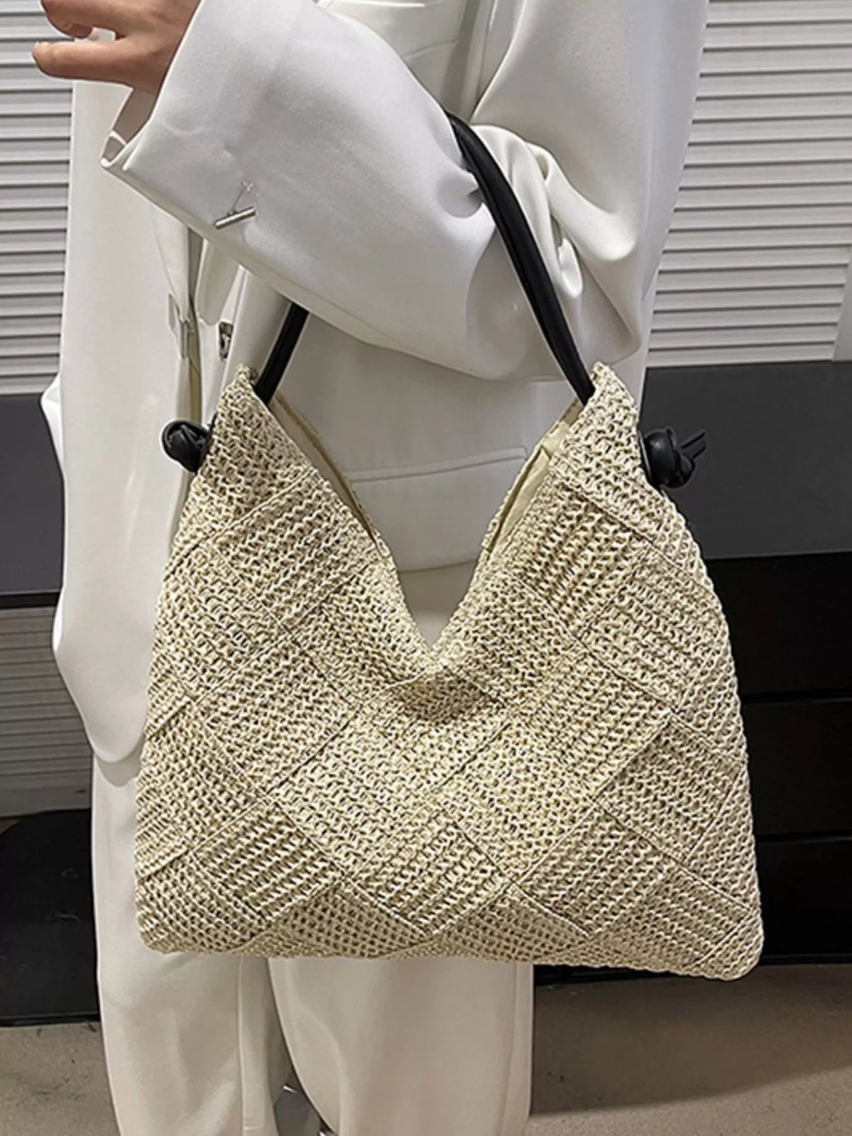 Model carrying woven straw shoulder bag