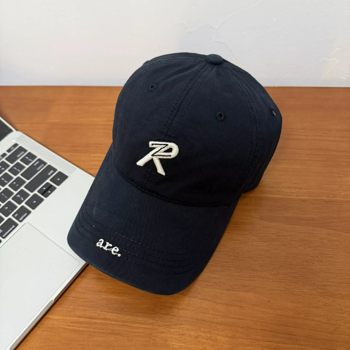 Letter embroidered baseball cap in black, front view