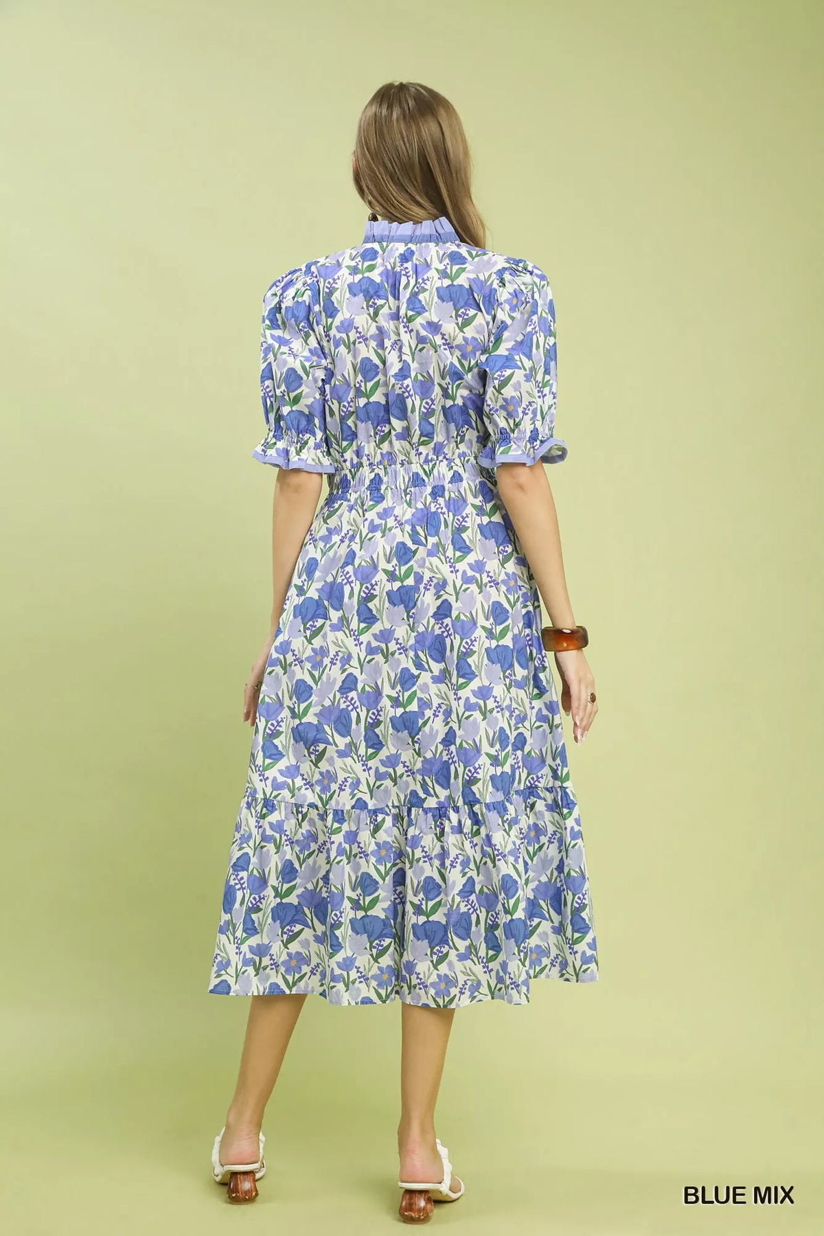 Close view of the ruffle trimmed V neckline and large floral print