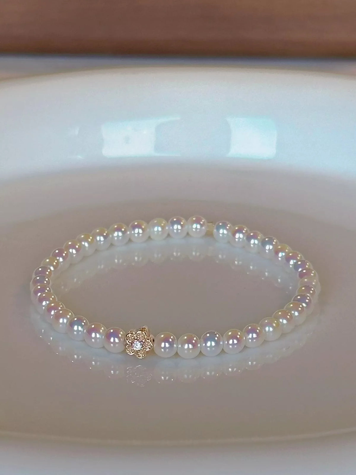 White pearl bracelet with gold floral accent