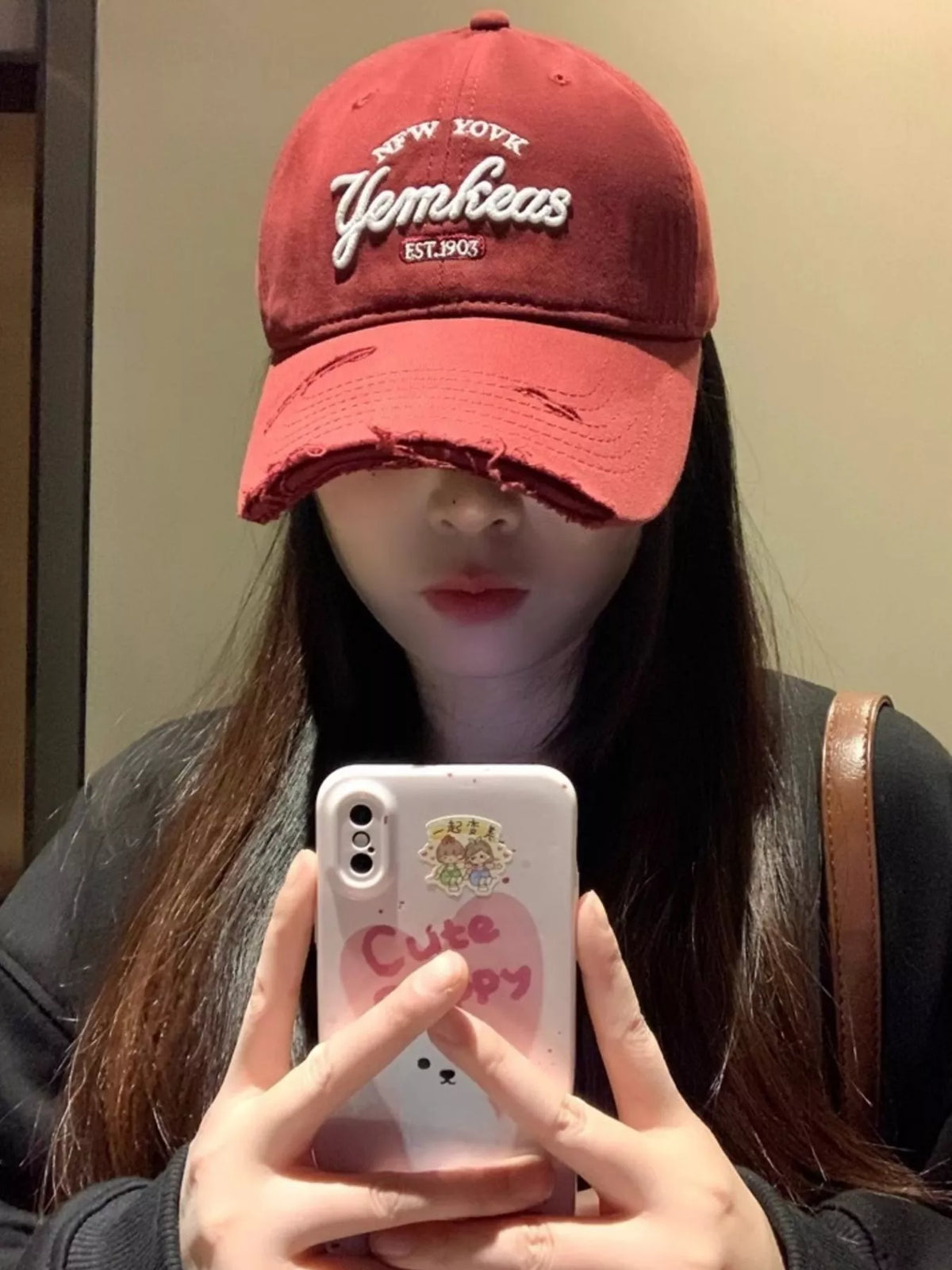 Embroidery detail on the wine red cotton cap
