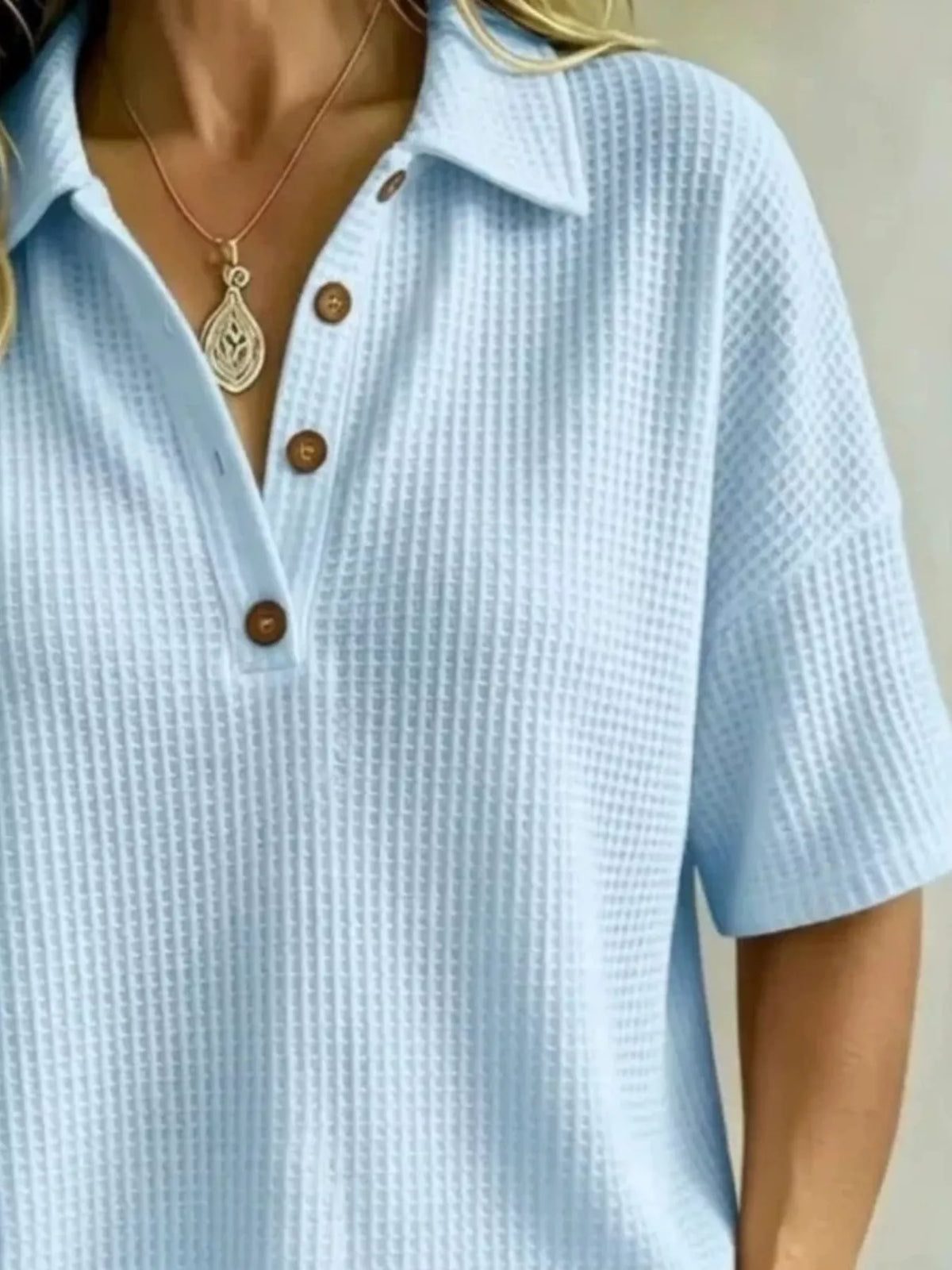 Close up of the waffle knit texture and buttons on the polo top