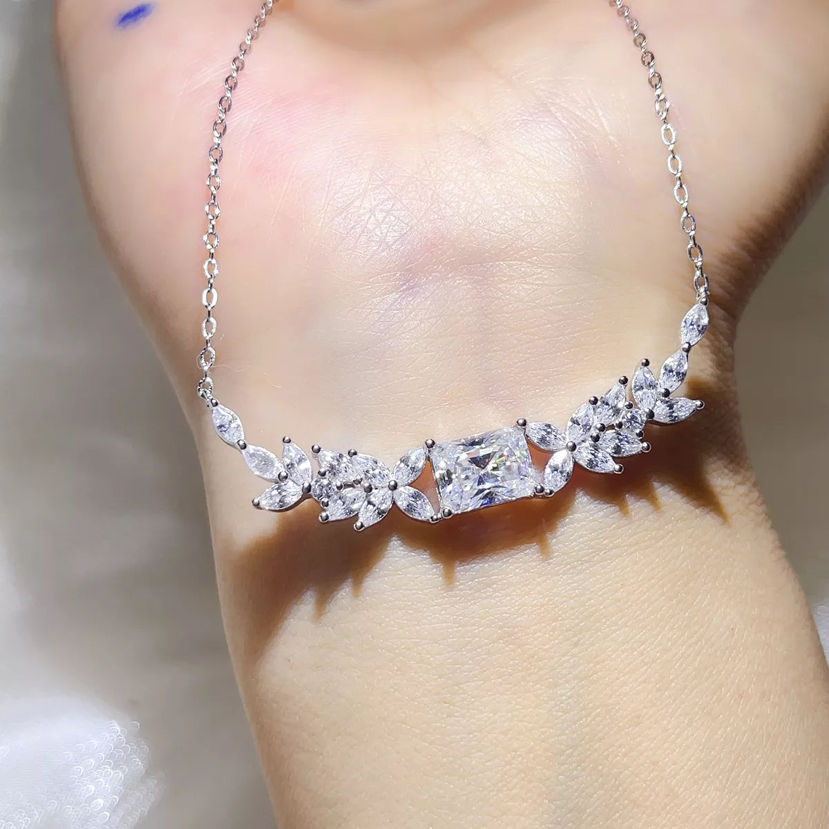 Sterling silver moissanite necklace worn on the collarbone