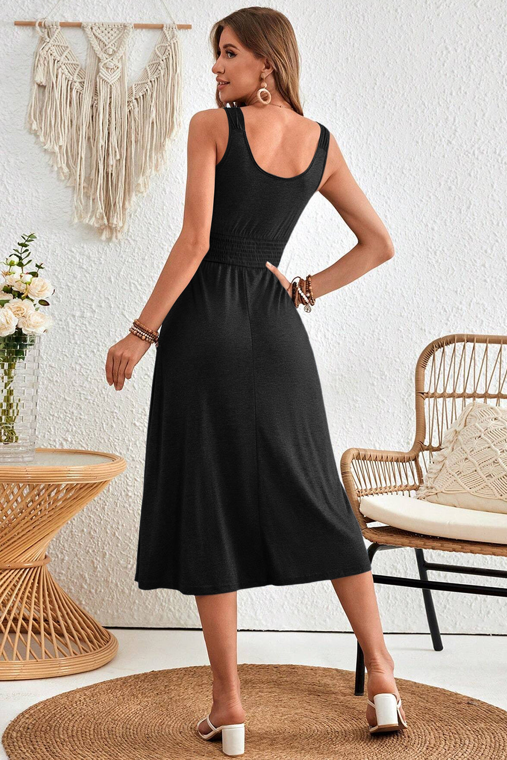Black shirred midi dress showing fit and flare silhouette