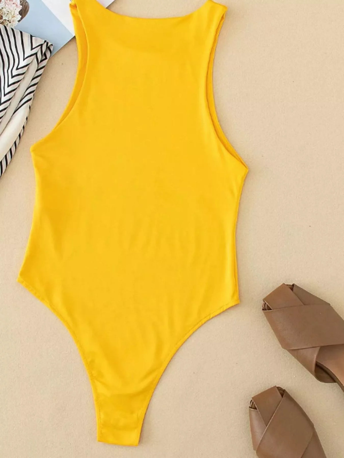 Colour range of sleeveless bodysuits laid flat