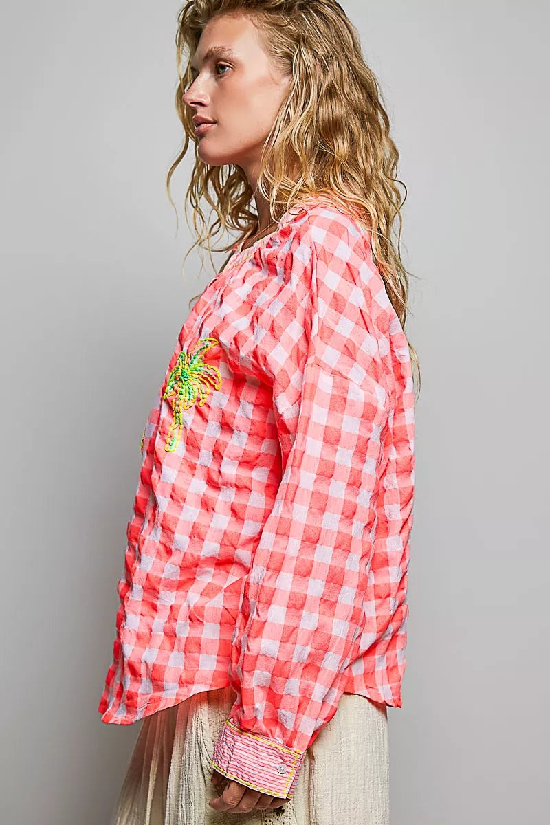 Embroidered palm tree motif detail on the gingham blouse