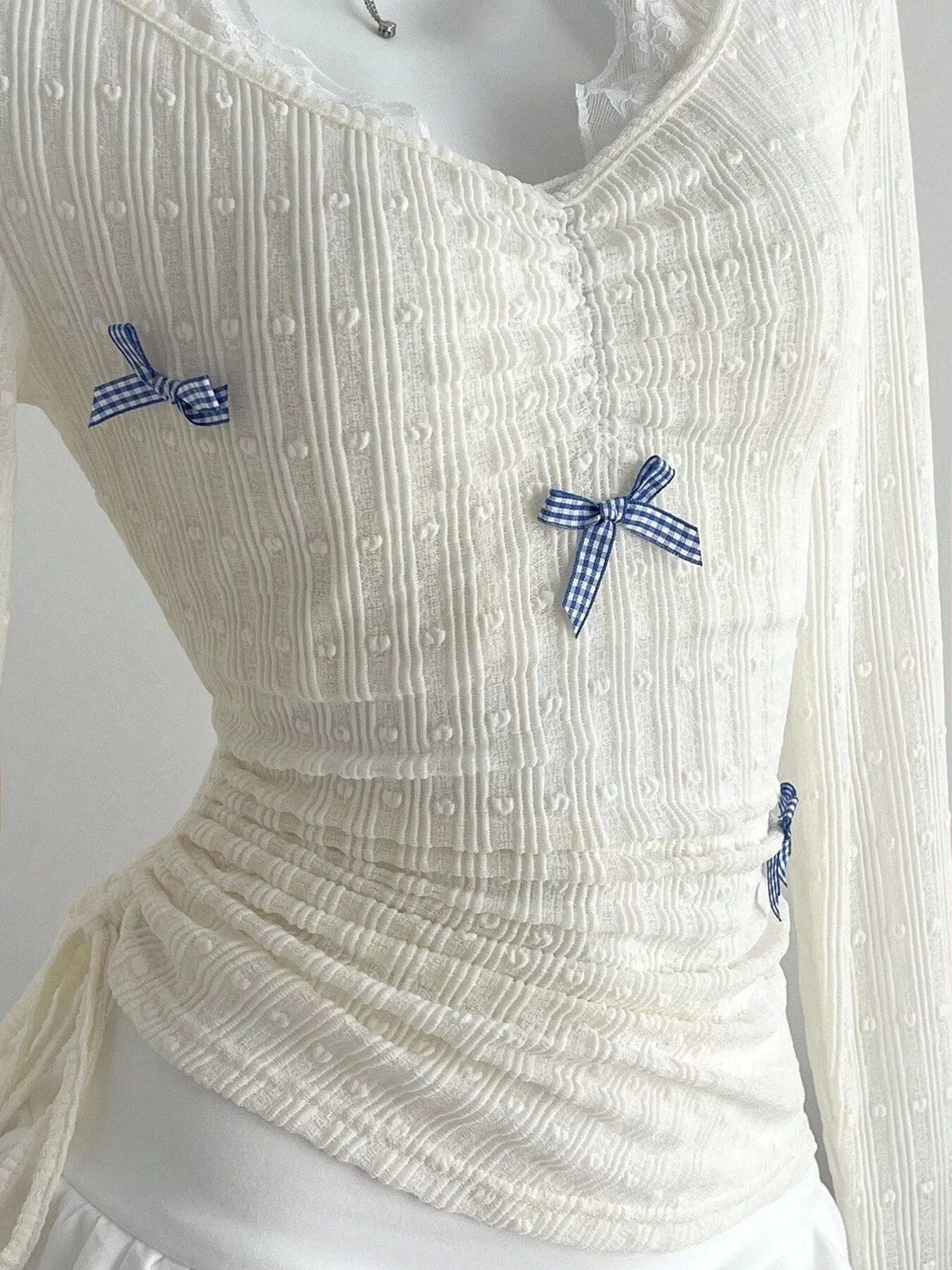 Textured fabric and sleeve detail of the fitted top