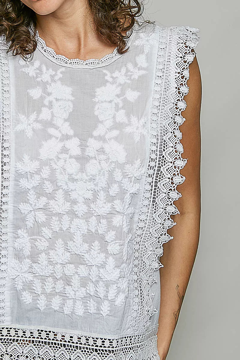 Embroidered sleeveless top styled with trousers