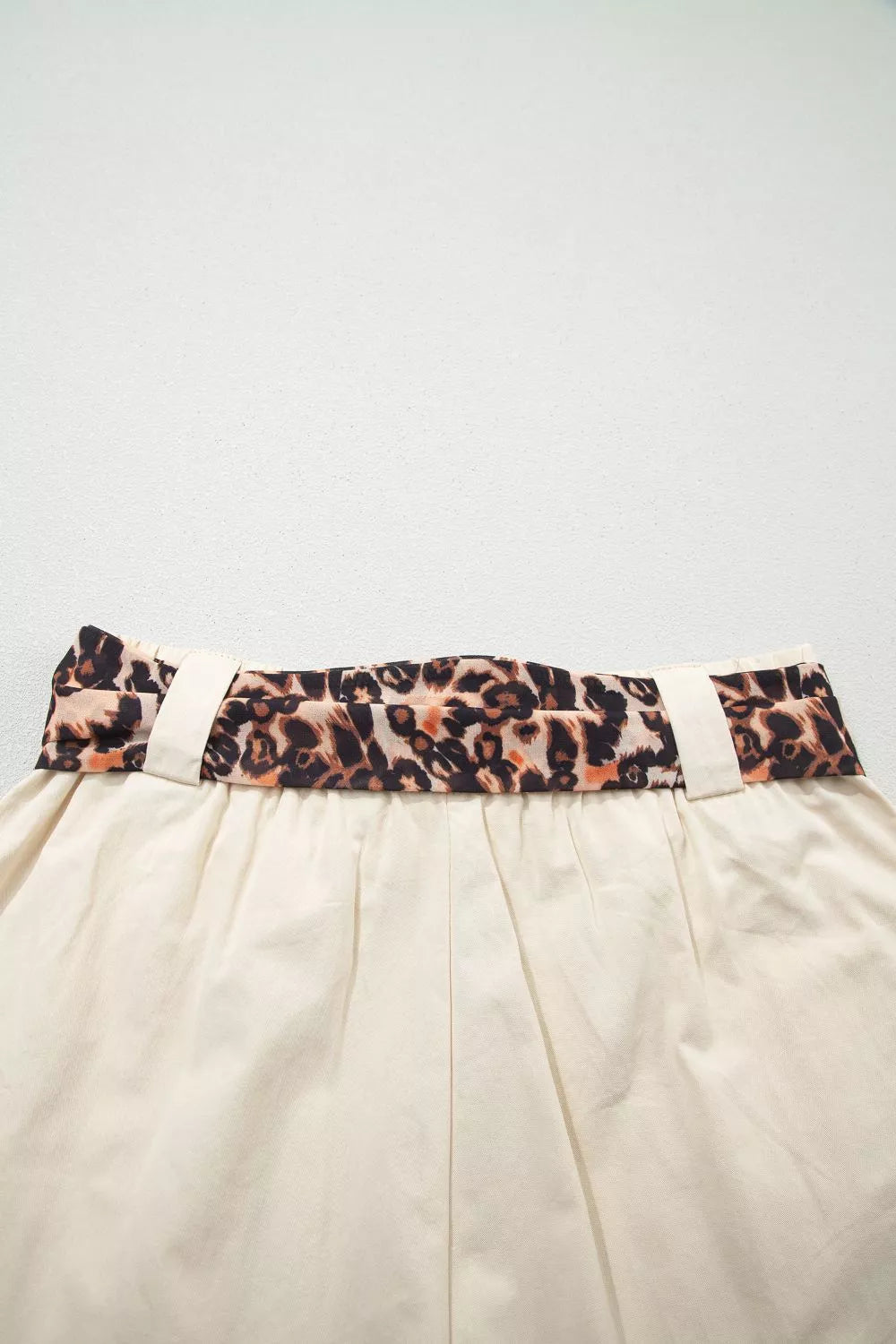 Beige high waisted pleated shorts close up view