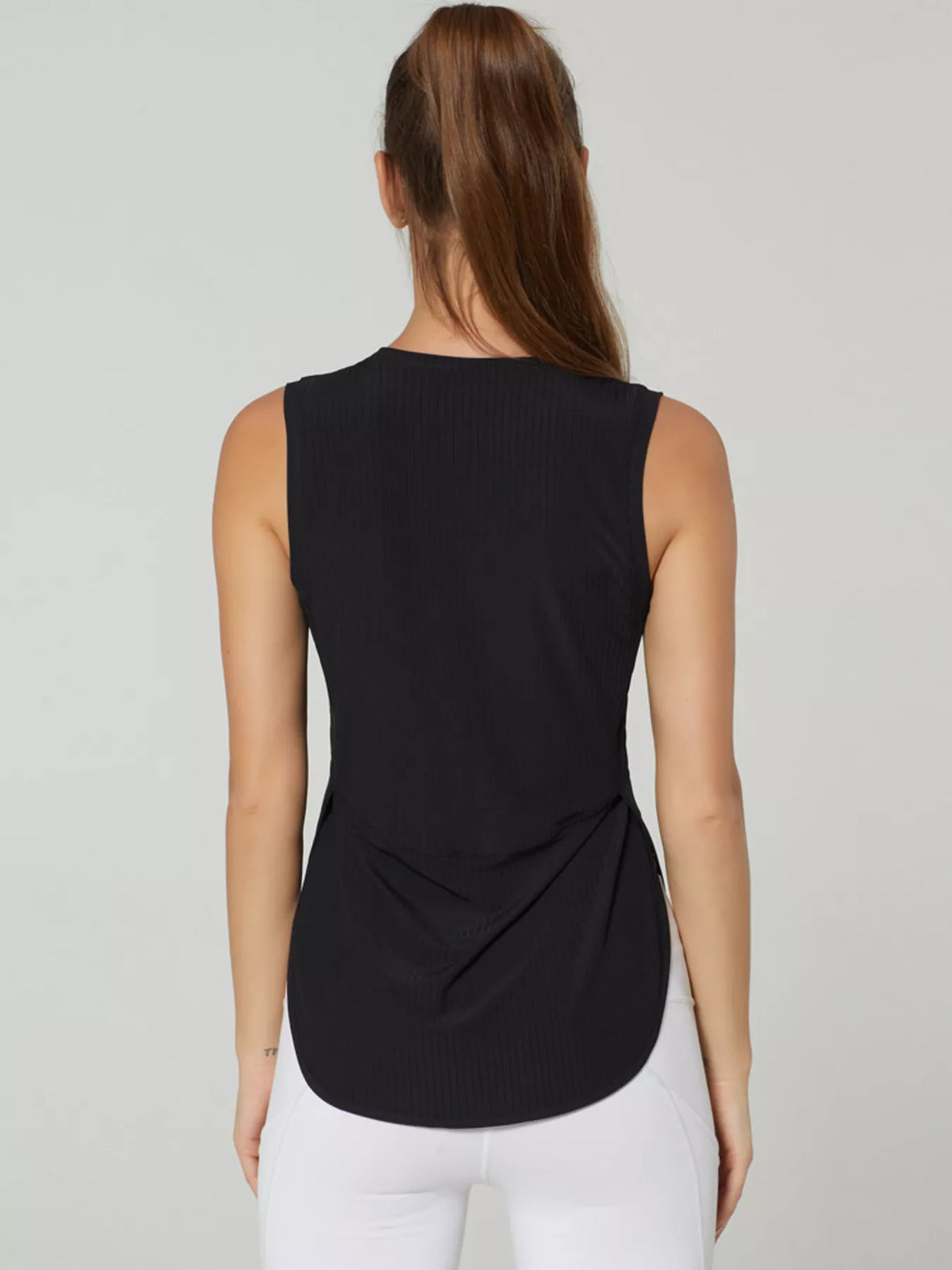 Model wearing the ribbed tank in a relaxed pose