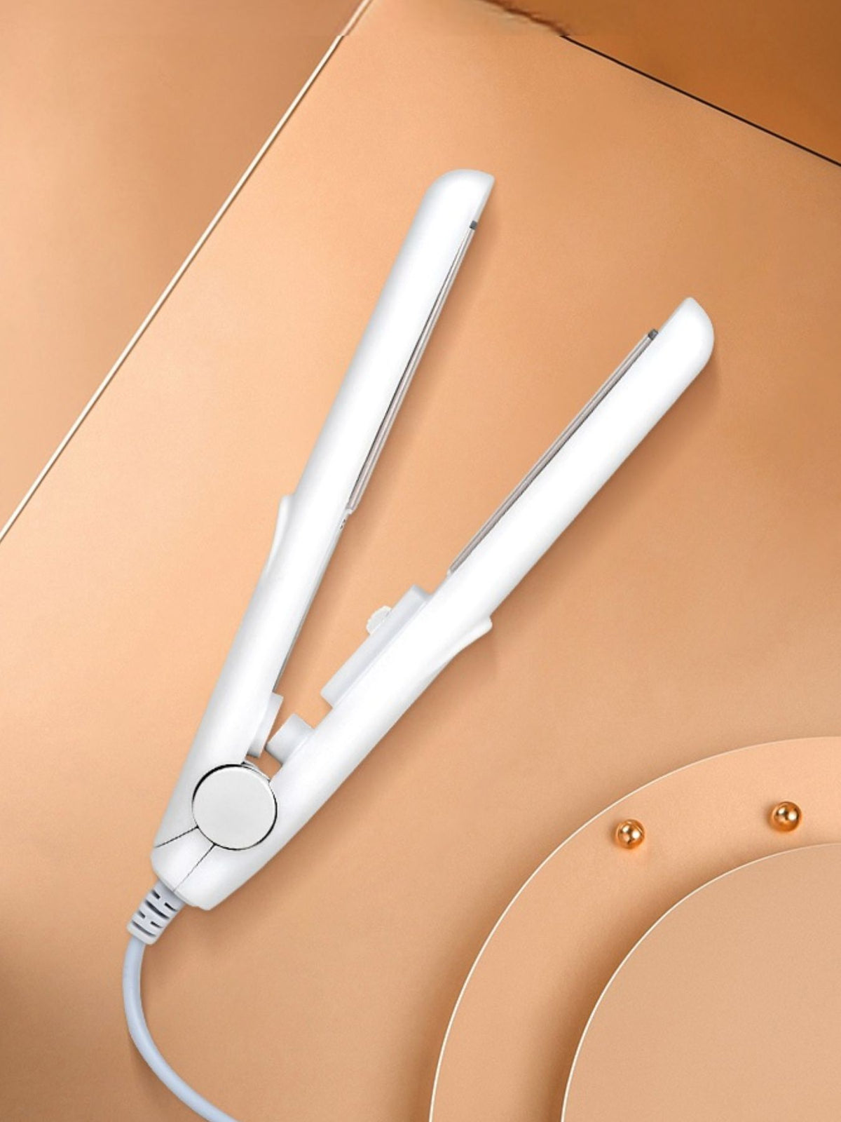 Mini straightener held in hand for scale