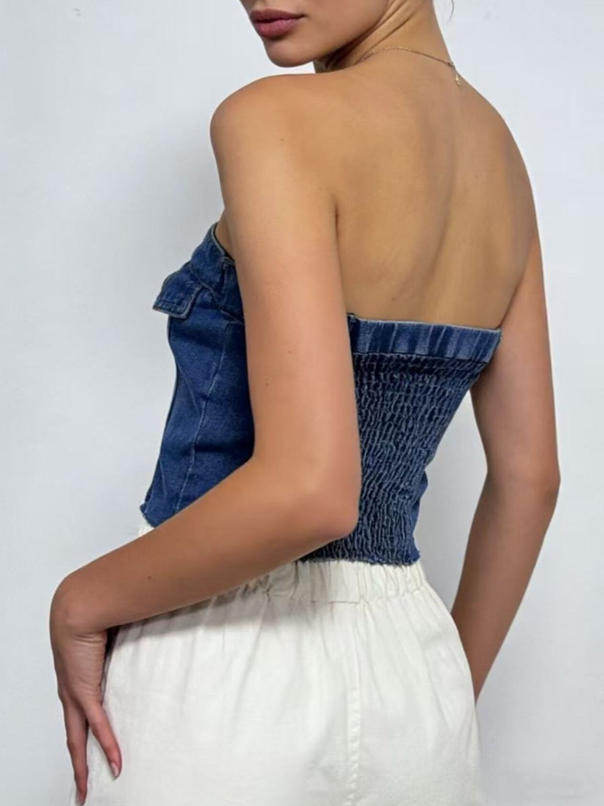 Raw hem edge of the cropped denim tube top