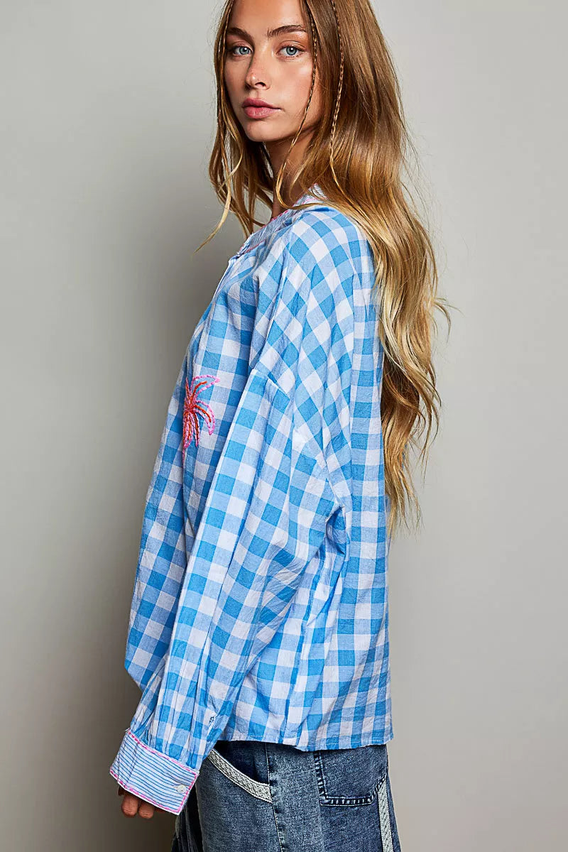 Front view of the gingham embroidered blouse on a model