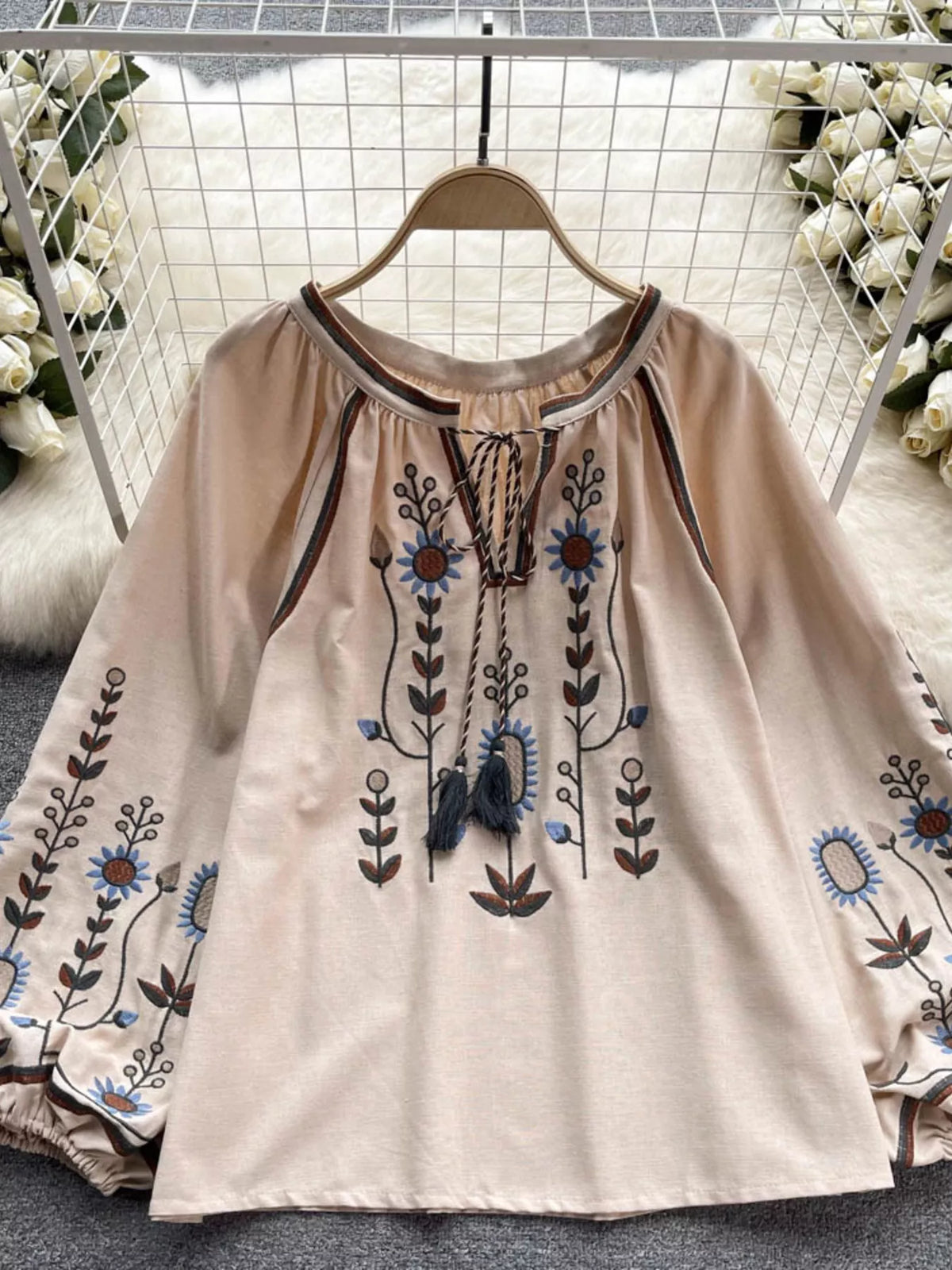 Embroidered tassel tie neck blouse, front view on model