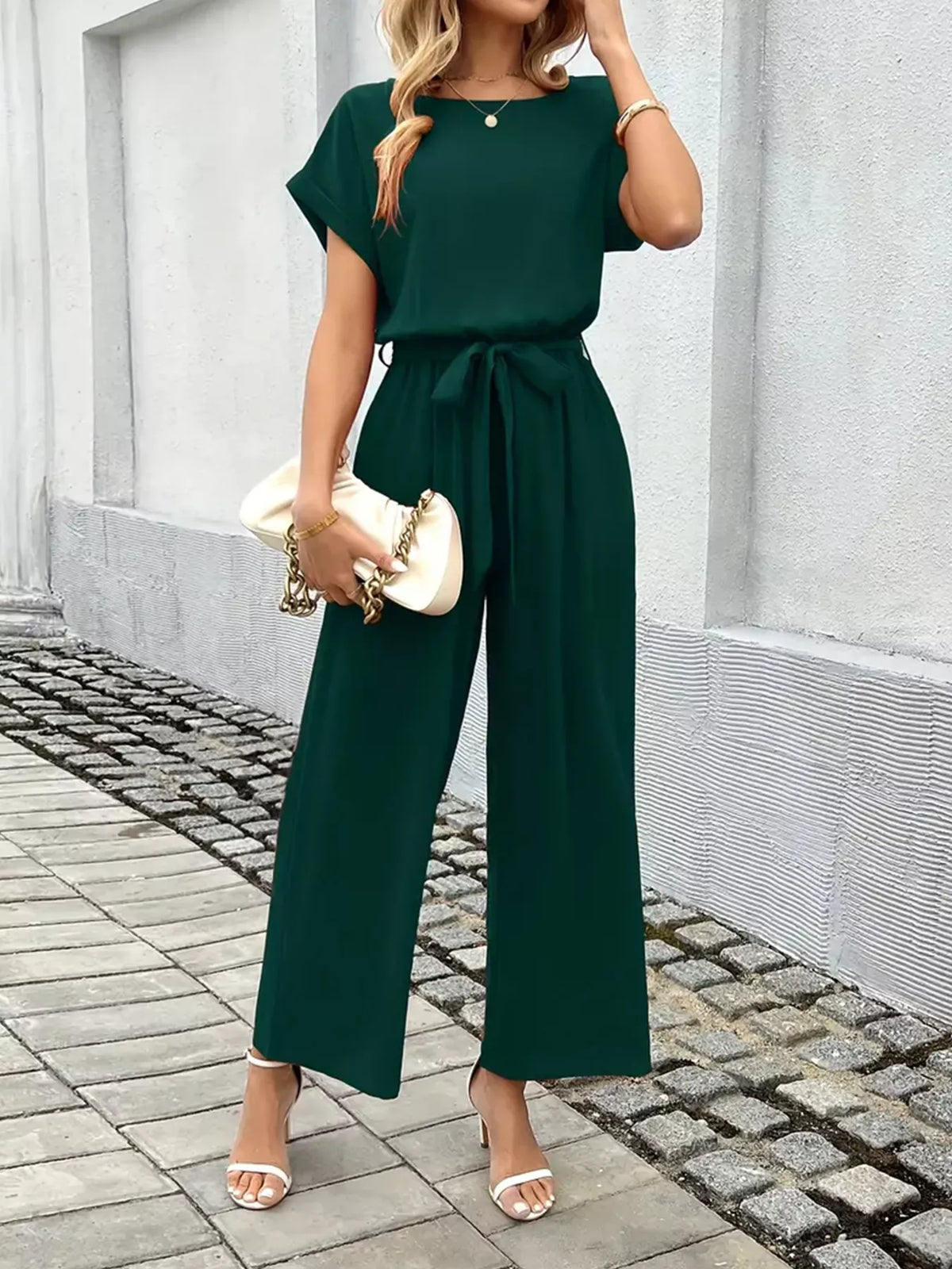 Model posing in tie waist wide leg jumpsuit
