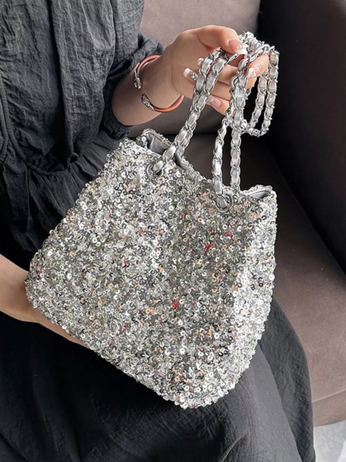 Sequin bucket bag carried by strap