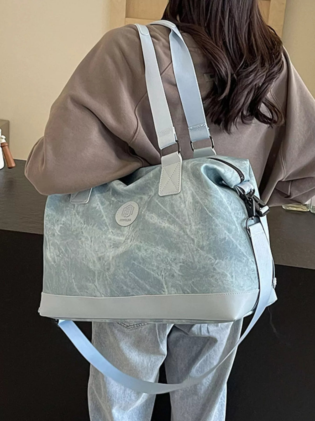 Leather duffel showing adjustable shoulder strap