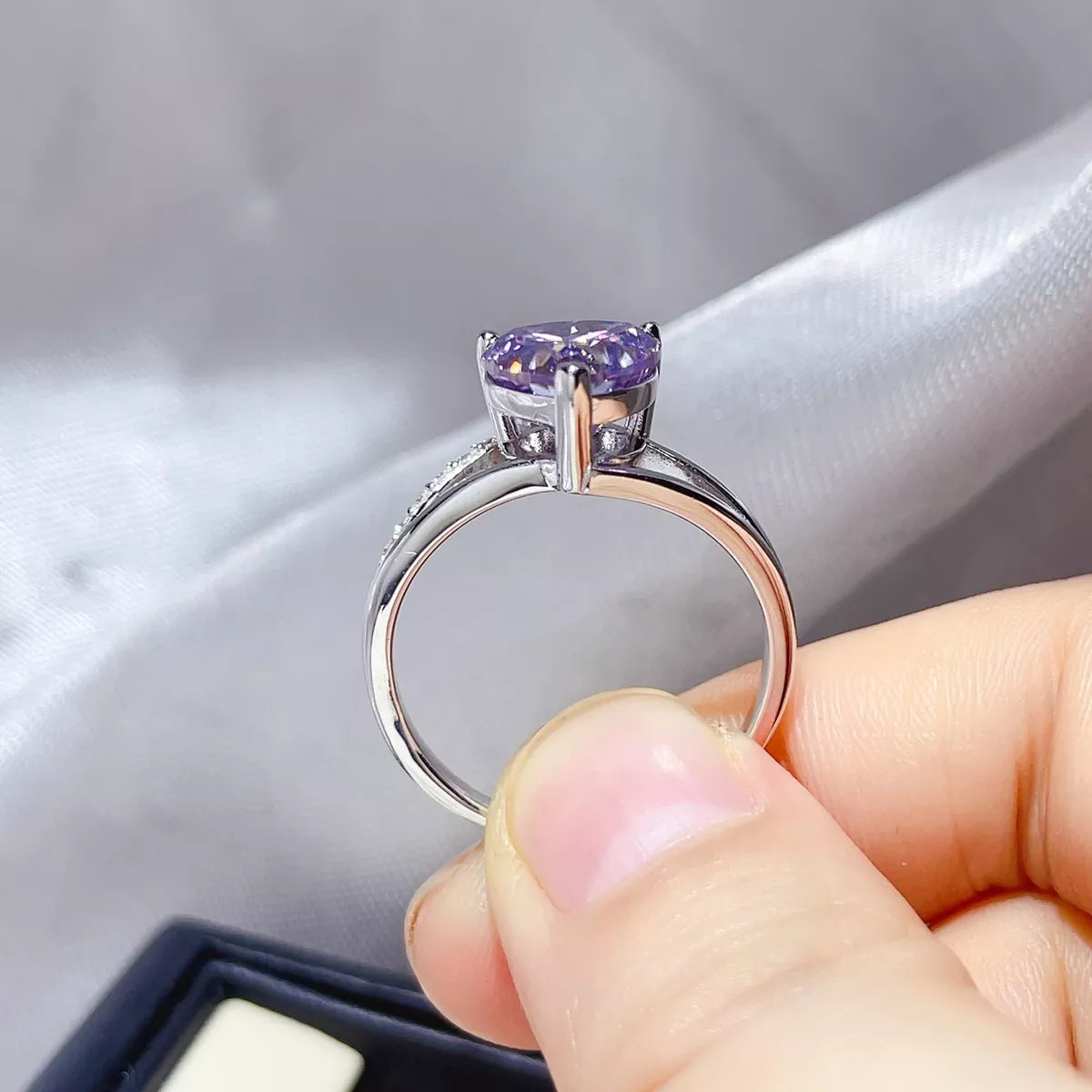 Moissanite ring shown on a hand from the front