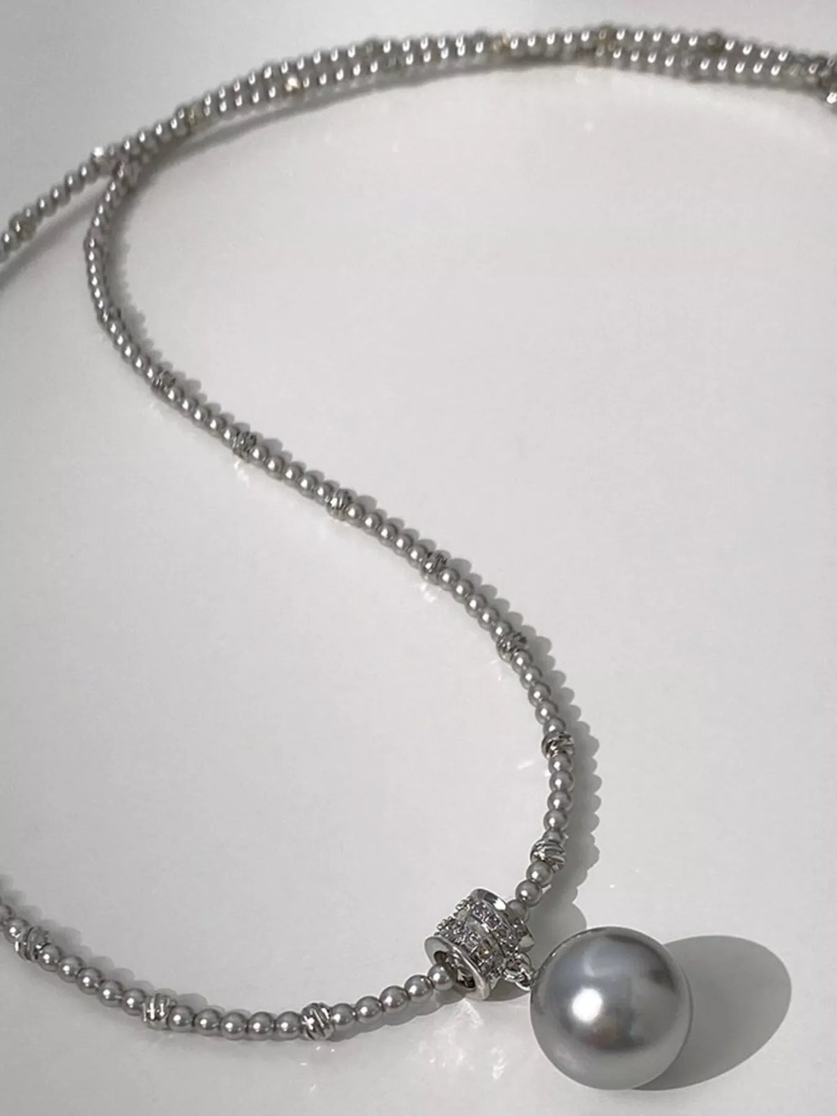pearl pendant necklace flat lay