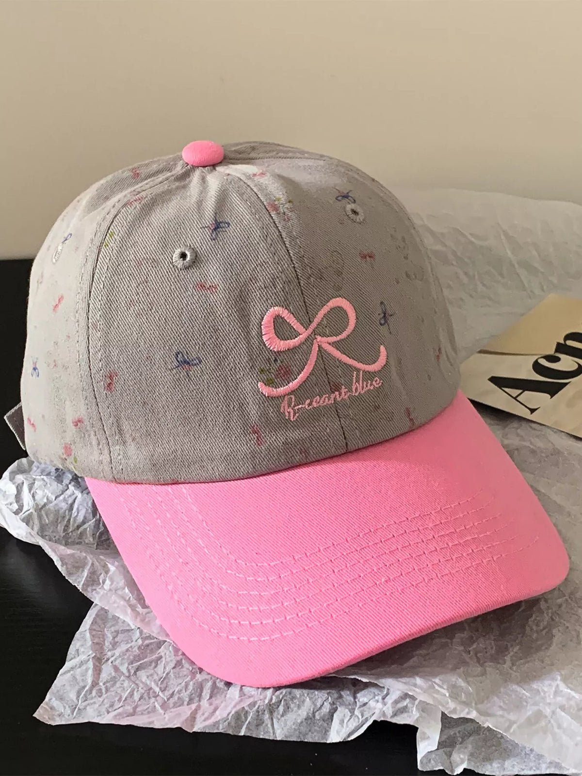 Close view of the embroidered bow detail on the cap