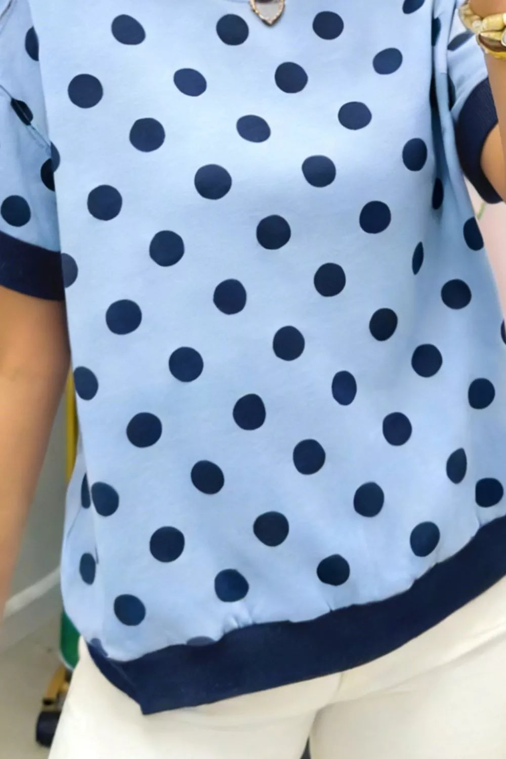 Model wearing polka dot round neck sweater