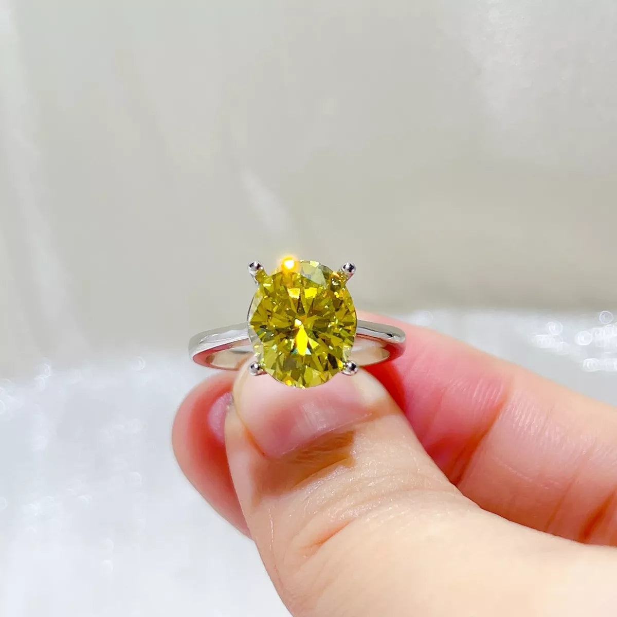 Light yellow moissanite ring shown from the side to display the setting