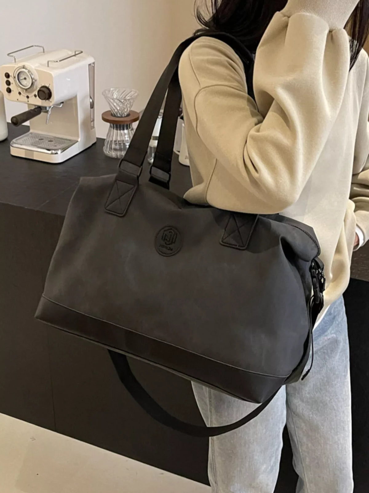 Black leather duffel with strap detail