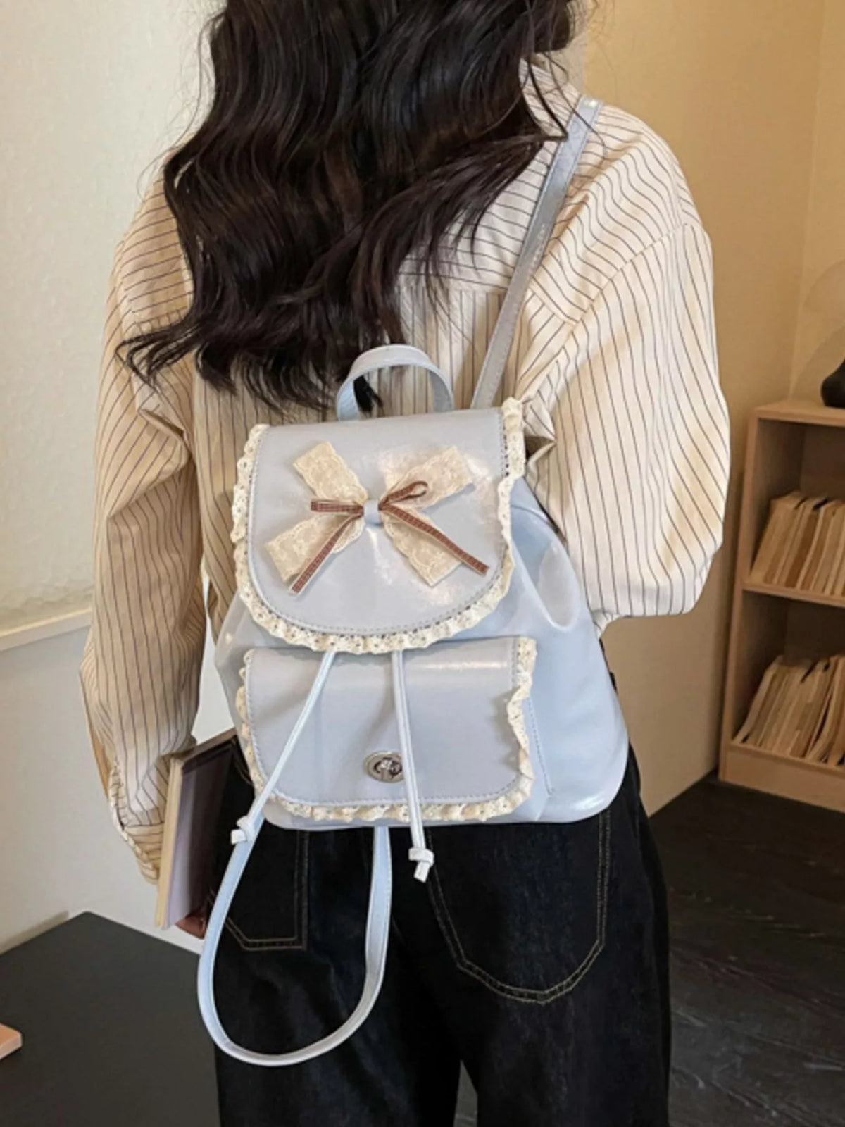 Blue lace bow mini backpack worn on the back