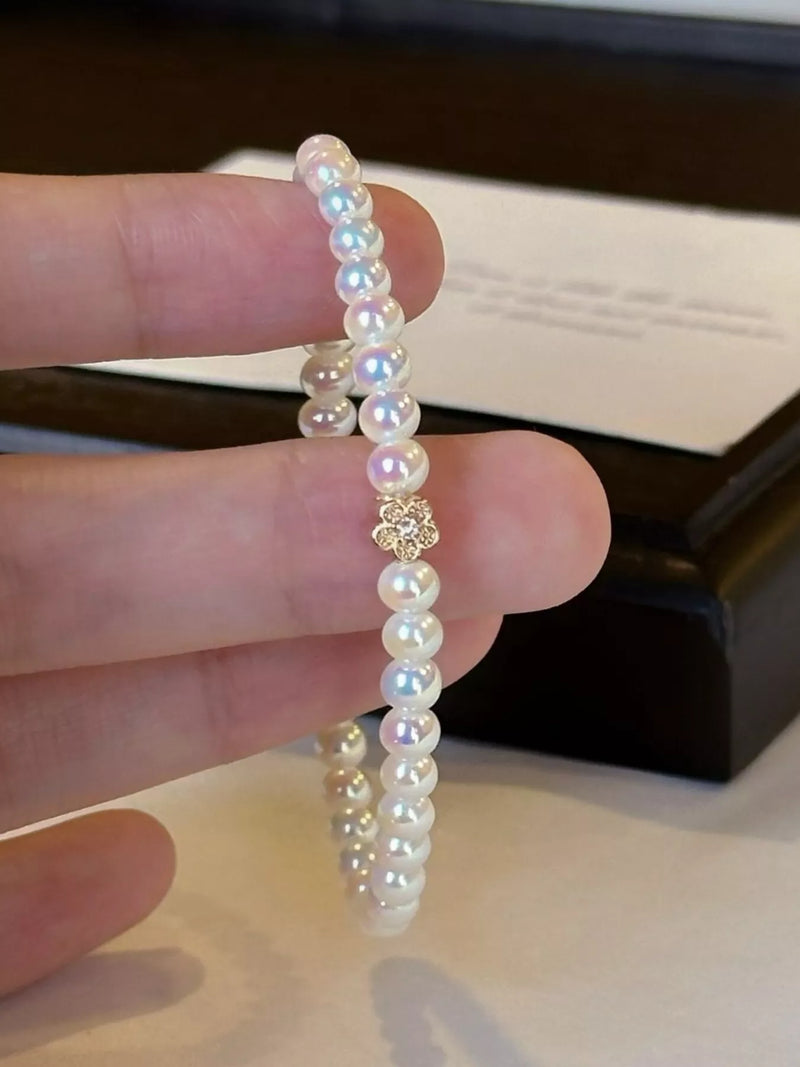 White pearl bracelet with gold floral accent
