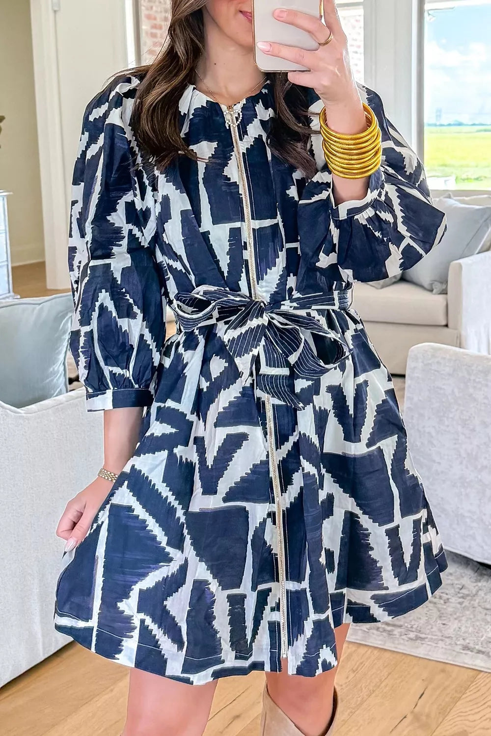 Close view of the zip front and abstract print detail on the navy shift dress