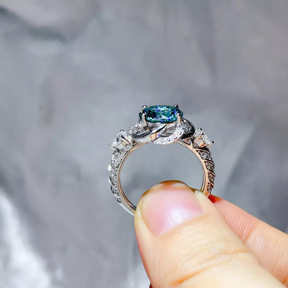 Close view of the green moissanite centre stone and accent stones