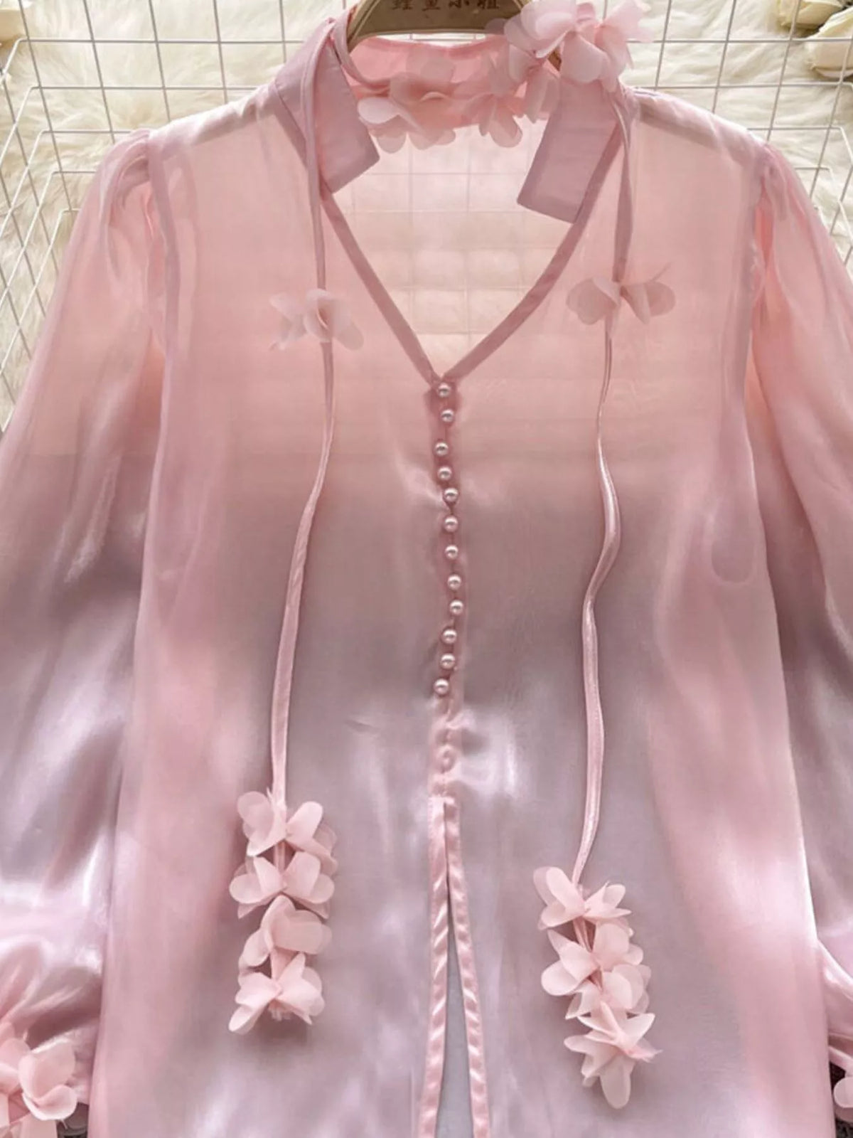 Embellished floral detail on the sheer shirt fabric