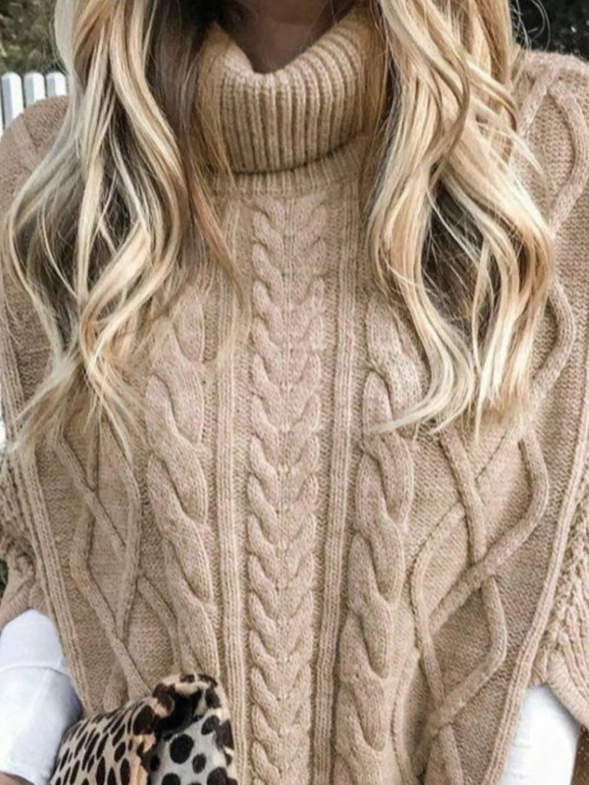 Chunky cable knit turtleneck poncho hem detail view