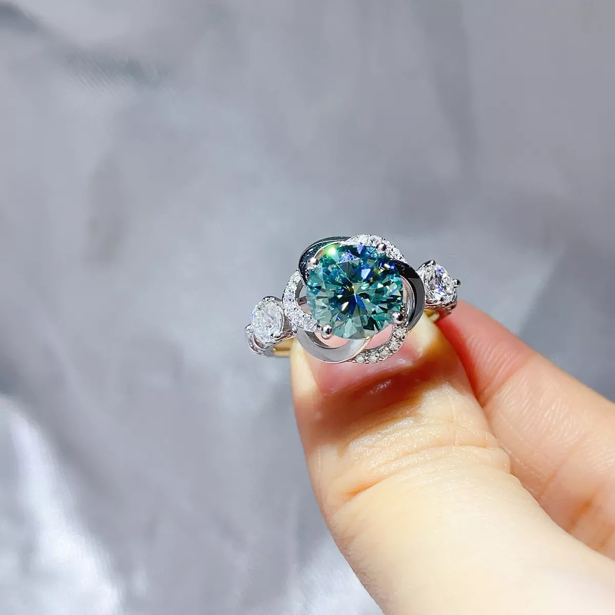Green moissanite ring shown from above to show the sculpted swirl setting