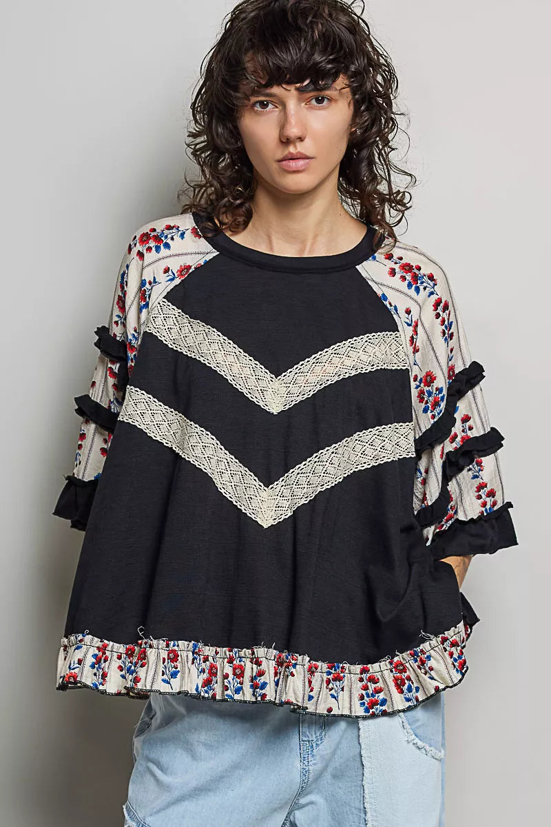 Black oversized knit top with contrast floral lace front view