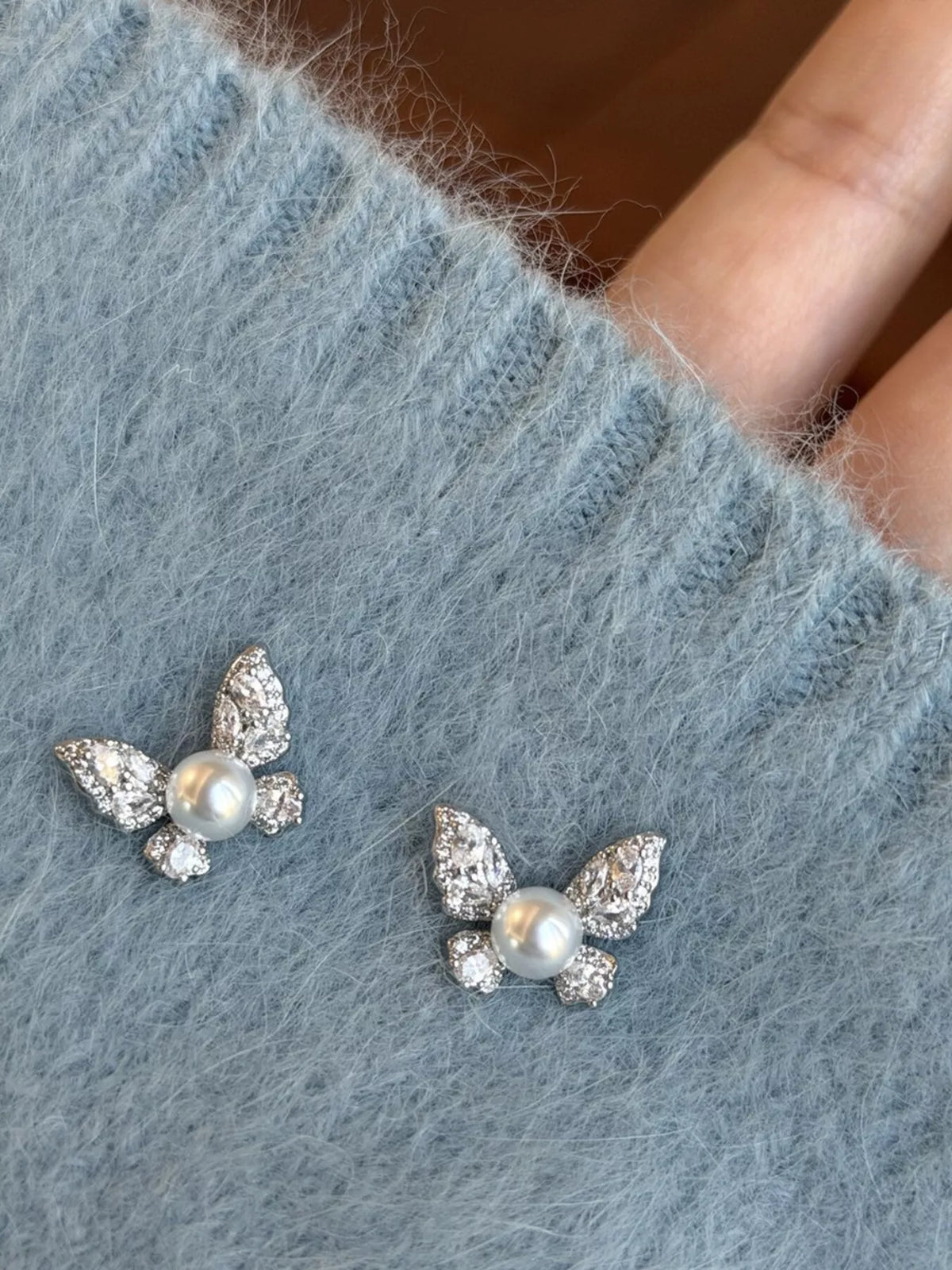 butterfly pearl stud earrings flat lay